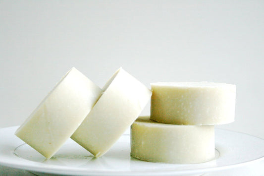 Lavender shave soap bars displayed on a white plate, showcasing their smooth texture and natural color.
