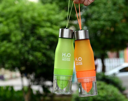 Lemon Fruit Juicer Bottles in green and orange, showcasing removable citrus press and hand grips.