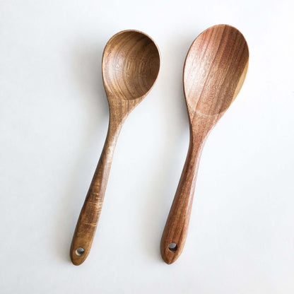 Natural acacia wood kitchen utensils set, featuring two handcrafted wooden serving spoons for durable cooking.