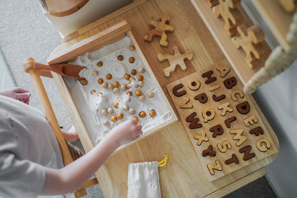 Child interacting with Natural Capital Letter Puzzle, eco-friendly learning toy, for letter recognition.