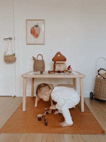 Child playing with a Natural Mushroom House wooden toy set on a rug in a bright room, fostering creativity and imaginative play.