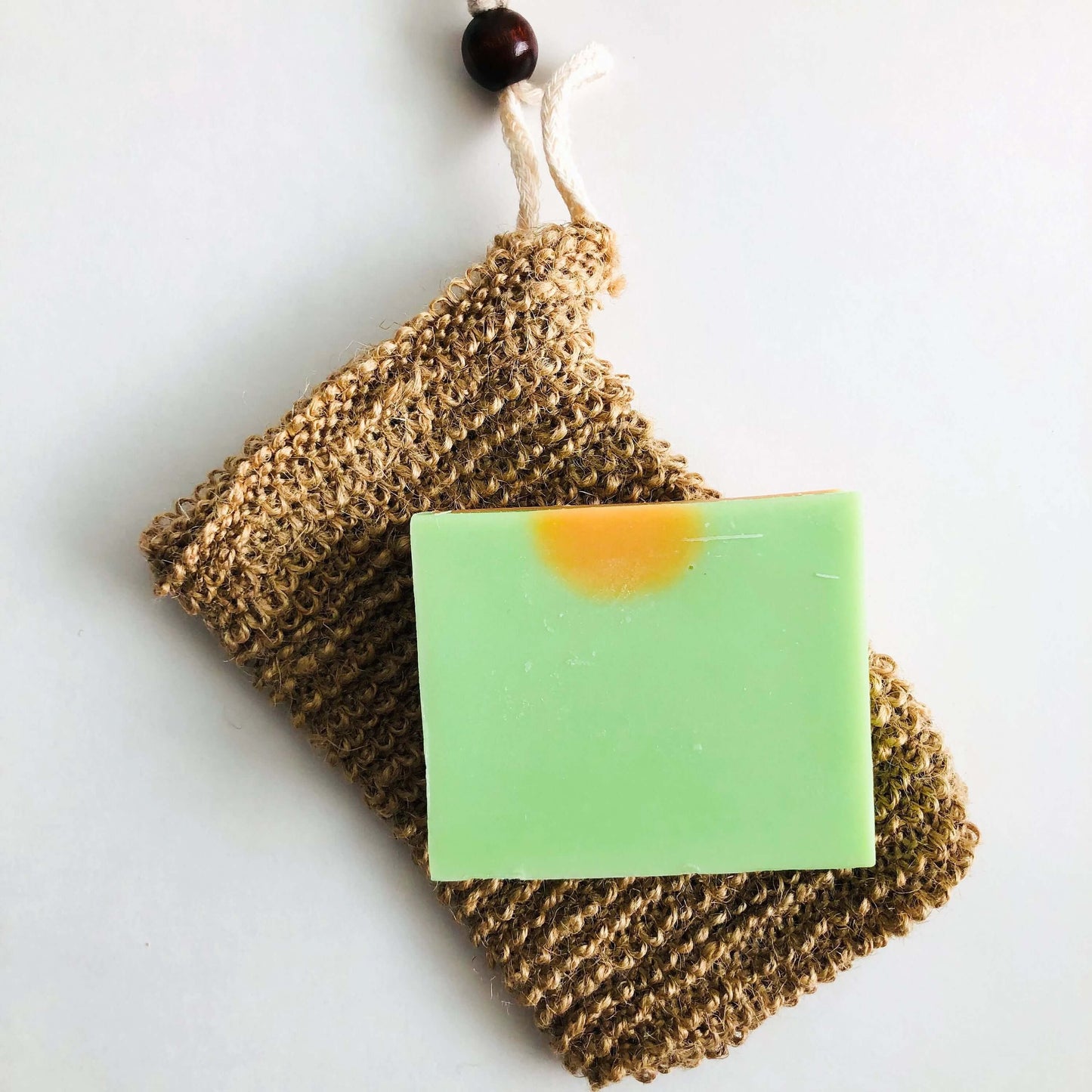 Natural organic jute soap bag with green handmade soap, perfect for zero waste hygiene.