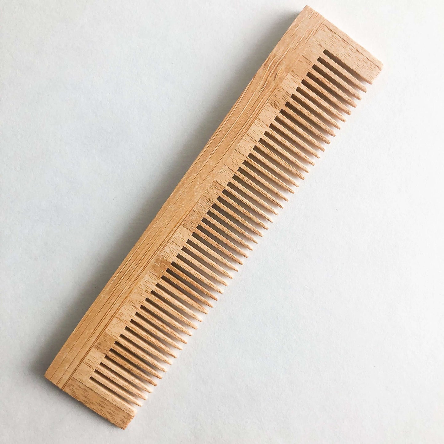 Plastic free natural bamboo comb with fine teeth, ideal for all hair types and gentle on scalp.