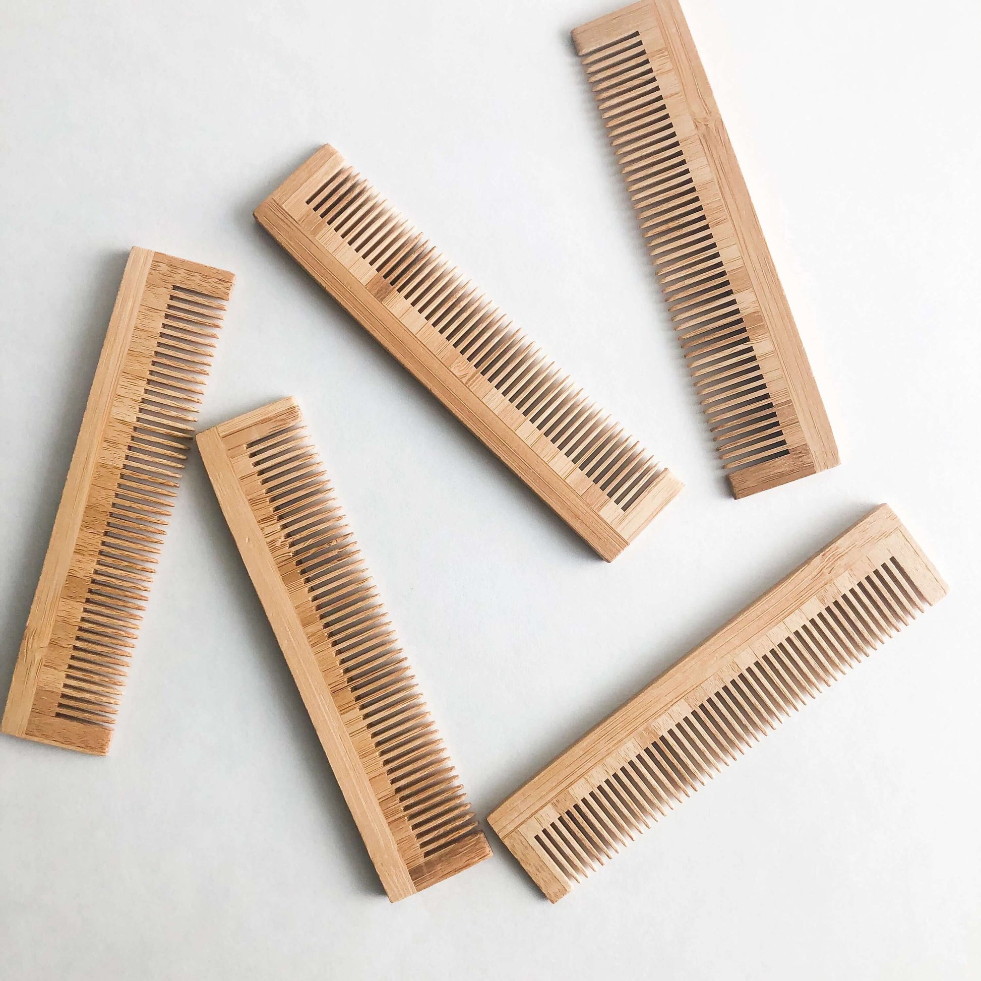Set of five eco-friendly bamboo combs, plastic-free and gentle on all hair types, ideal for zero waste grooming.