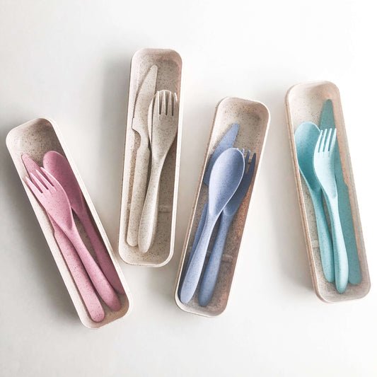 Eco-friendly reusable wheat straw cutlery set in four colors, stored in a natural fiber box for sustainable dining.