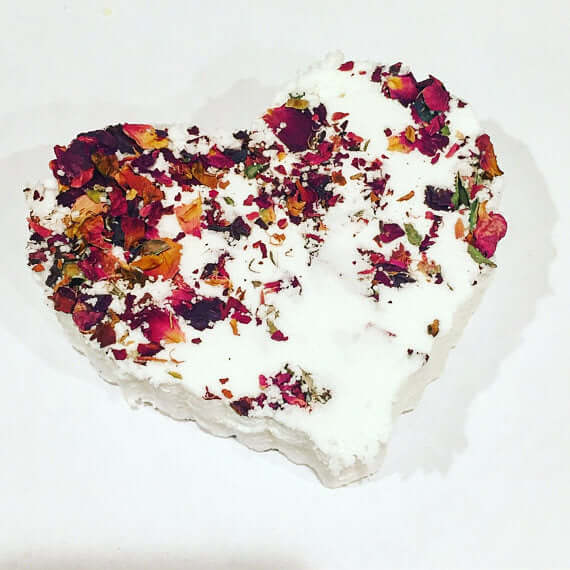 Heart-shaped bath bomb adorned with dried rose petals for a relaxing and hydrating bath experience.