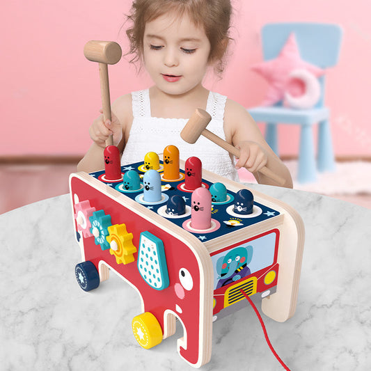 Child playing with vibrant wooden pounding bench toy featuring colorful animals and mallets for fun learning.