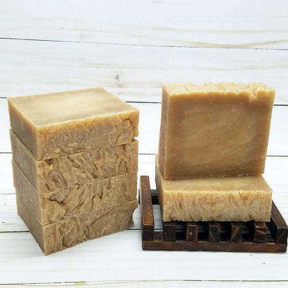 Vegan honey almond handmade soap bars stacked on a wooden drying rack, ideal for nourishing dry skin.